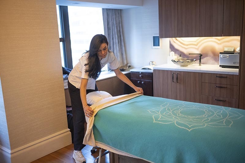 Licensed Massage Therapist Preparing Room