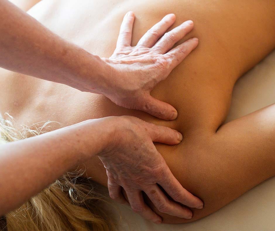 Massage therapist applying focused pressure during a professional massage session at ila Only Spa