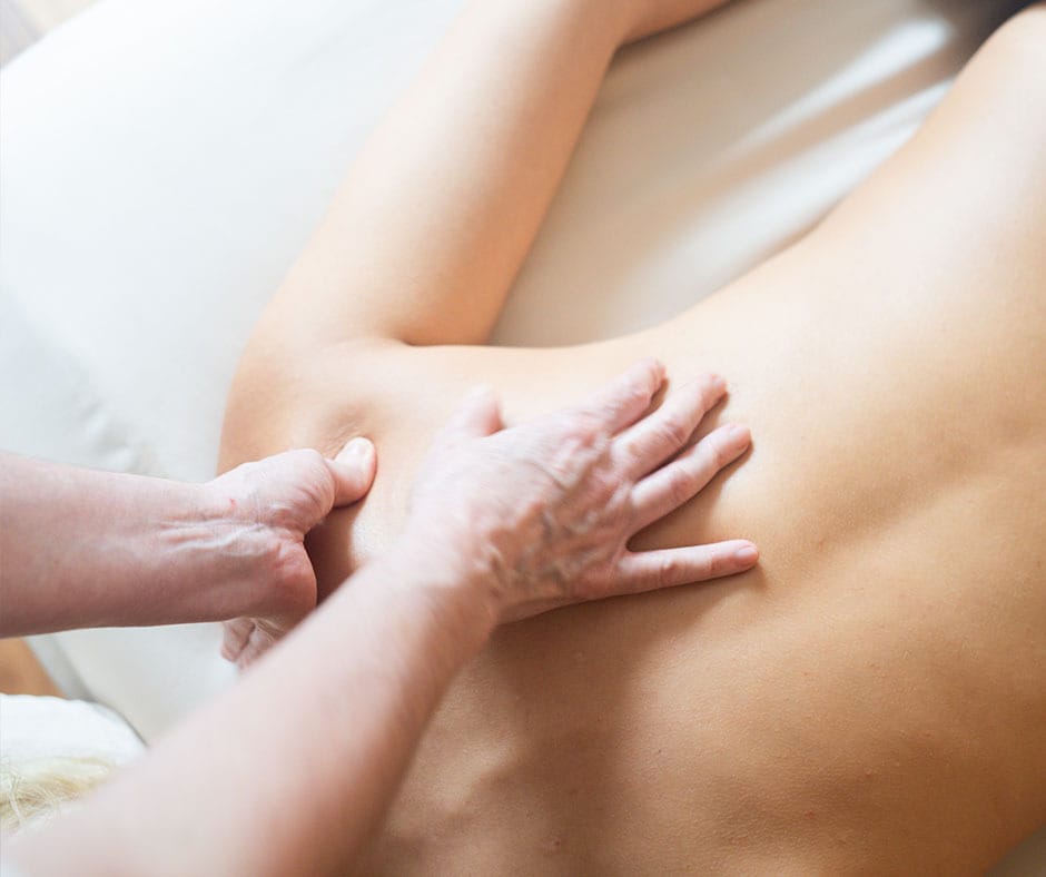 Therapist performing Swedish massage techniques on the back