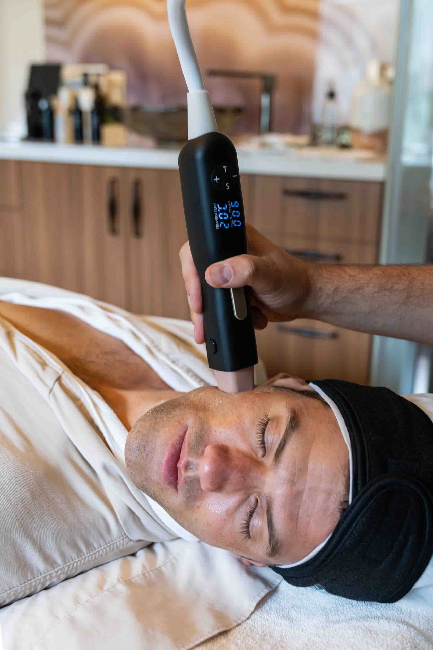 Esthetician performing a non-surgical facial skin tightening treatment on a male client at ila Only Spa in Midtown Manhattan.